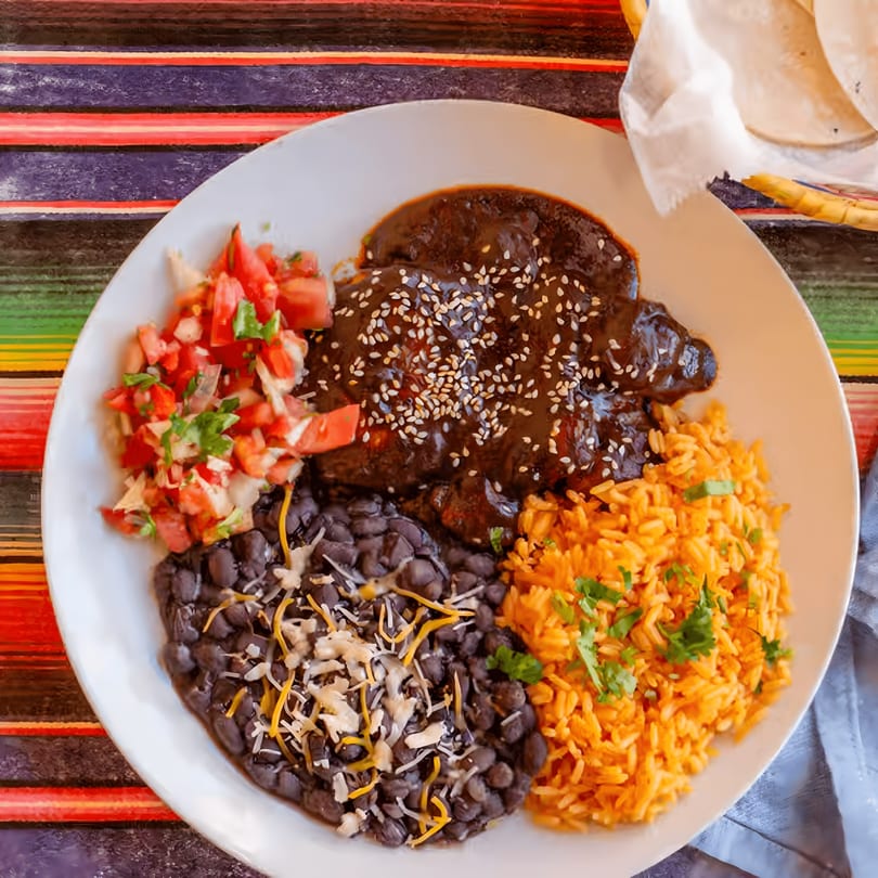 El Vaquero Mexican Taqueria's mole poblano with rice, black beans, and pico de gallo.